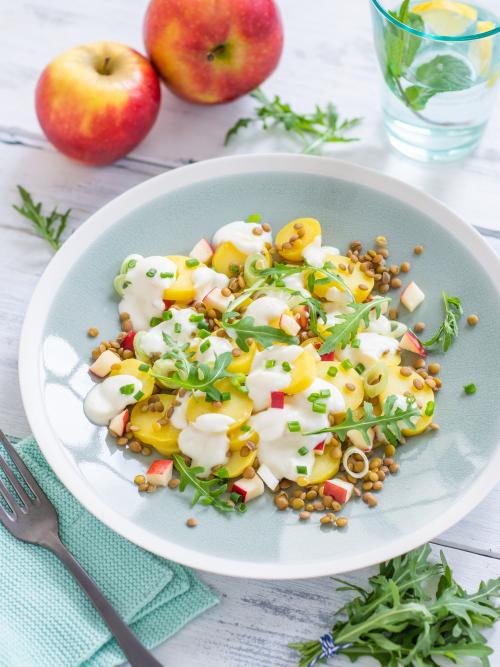 Kartoffelsalat mit Linsen und Apfel serviert in einer Schale